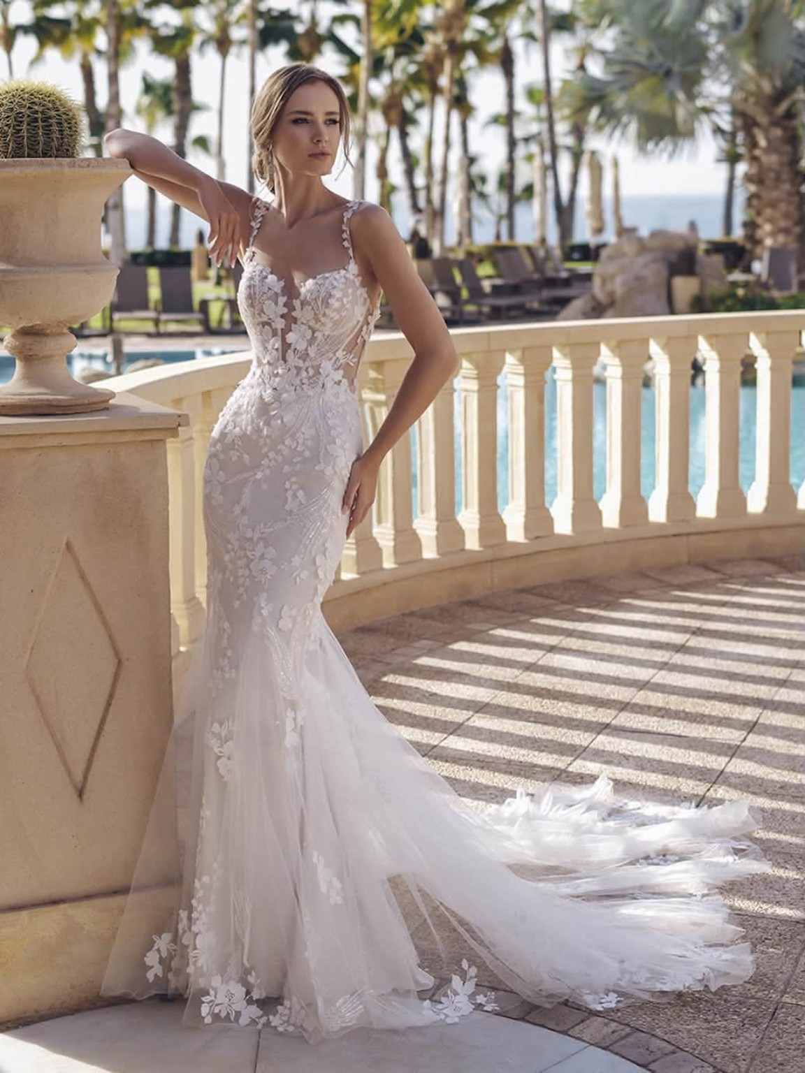 Bride in a floral lace gown on a sunlit terrace